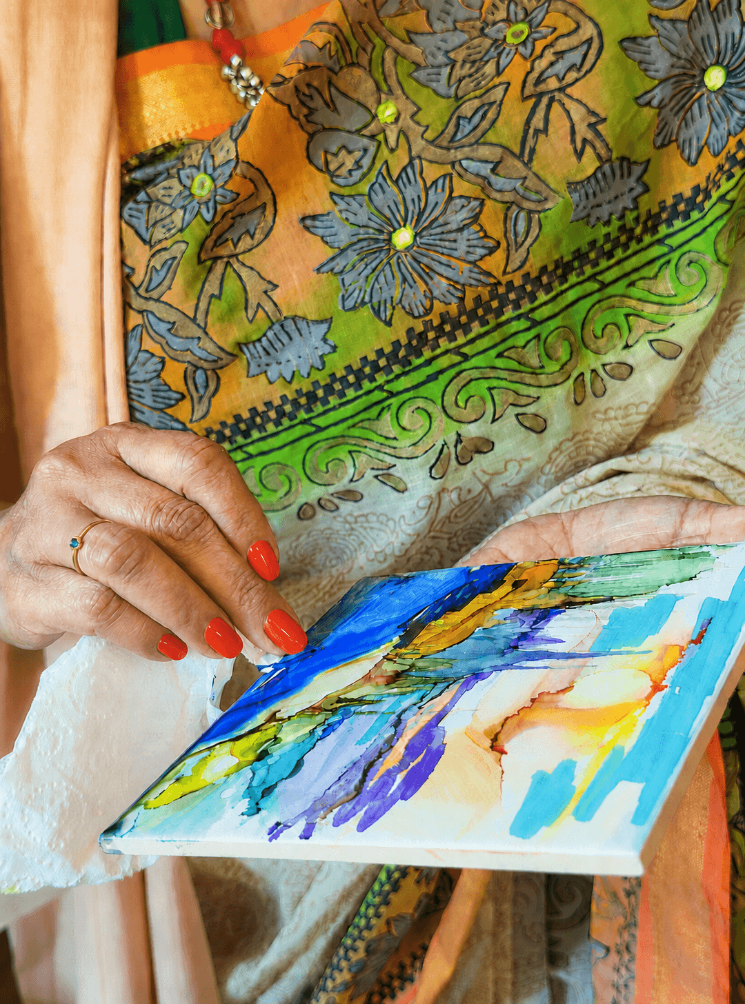 A guest painting a colourful abstract artwork at Drips & Flows